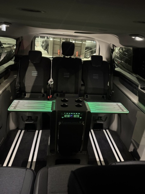 BOX TABLE z zielonym podświetleniem LED, rozłożony na całą szerokość kabiny Forda Tourneo Custom.
