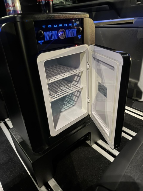 Wersja BOX TABLE z lodówką, otwarte drzwiczki z półkami chłodziarki.